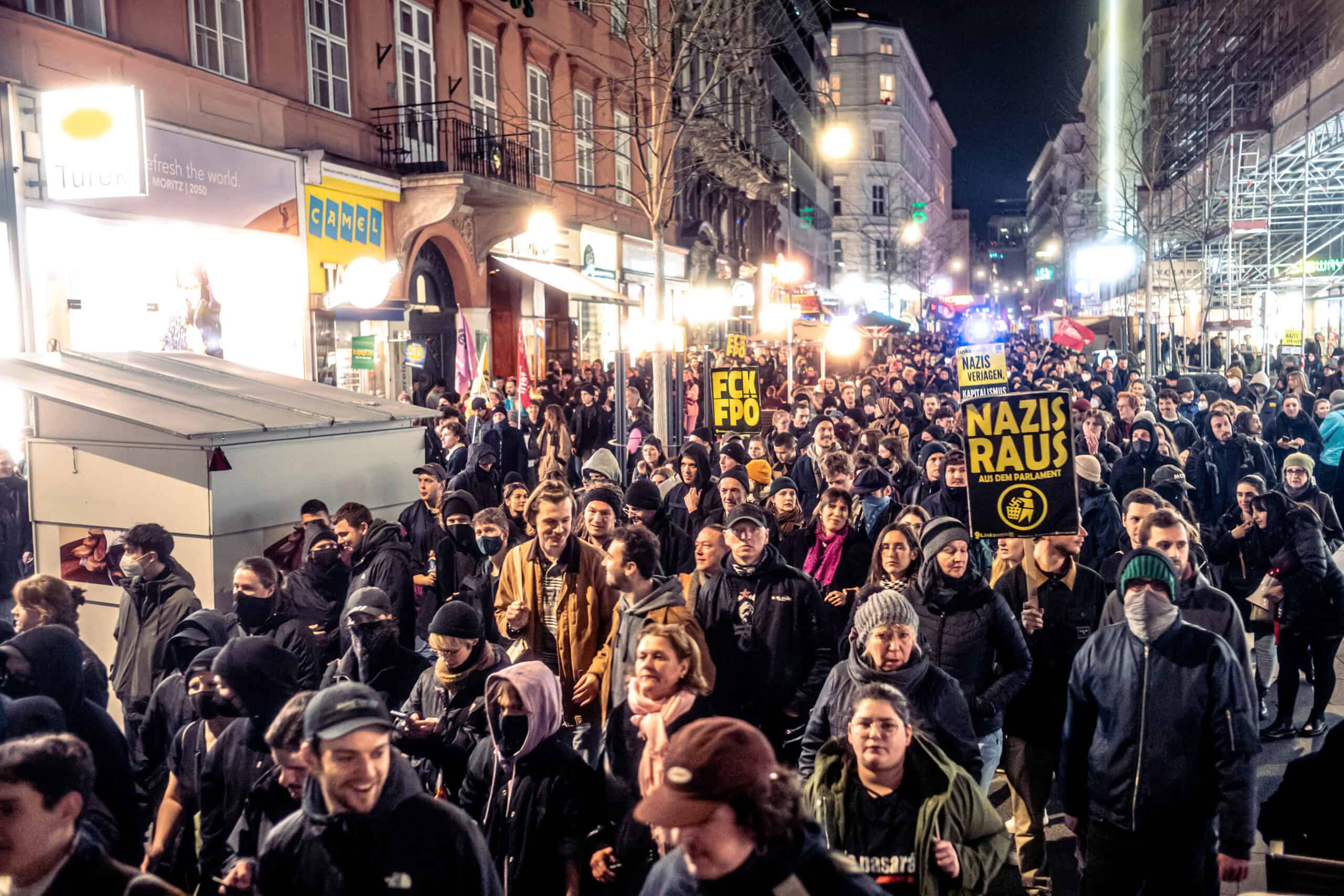 Eine große Demonstration. Zahlreiche Menschen ziehen nebeneinander durch eine Straße, manche von ihnen tragen Schilder mit Slogans gegen Rechts.